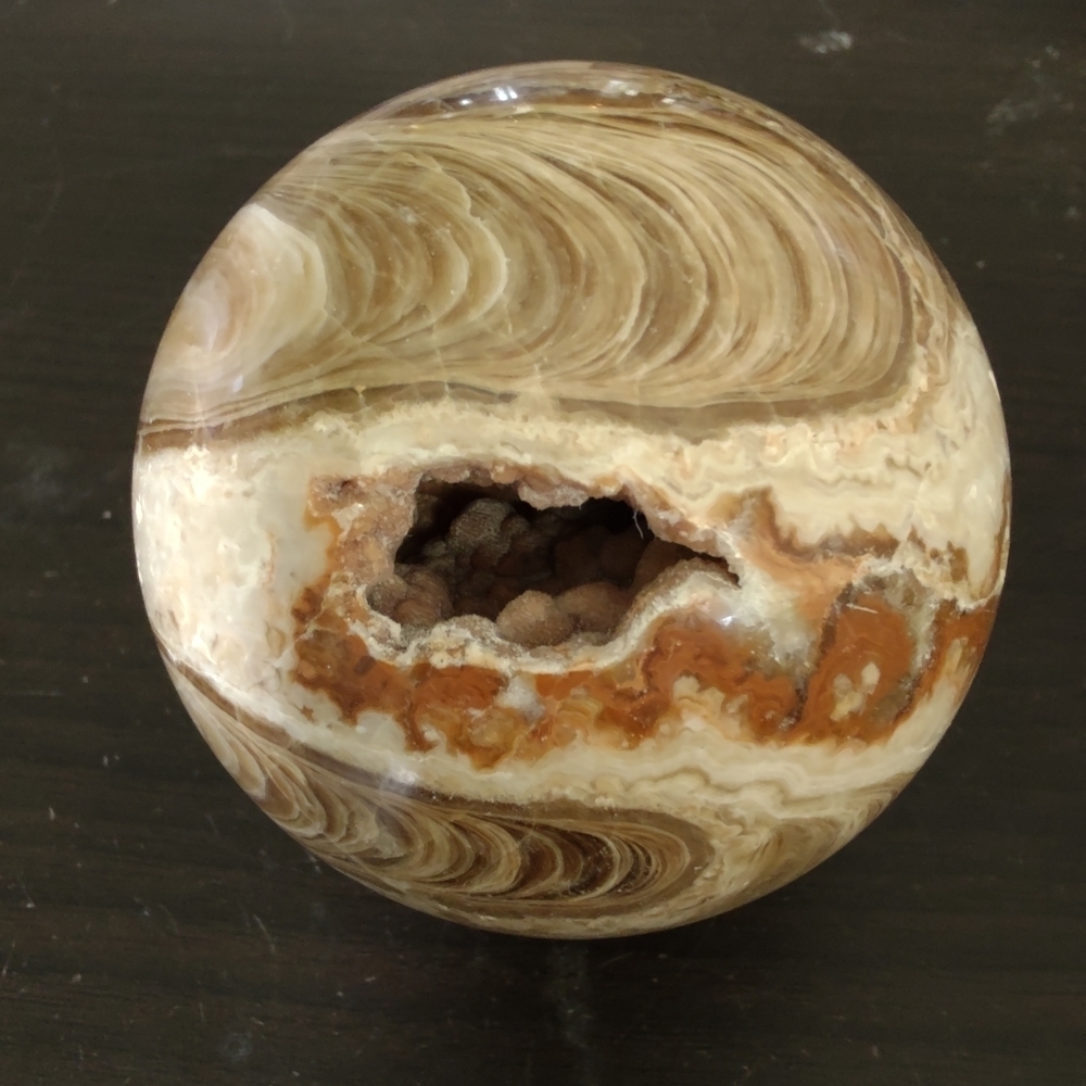 Amber calcite sphere with cave